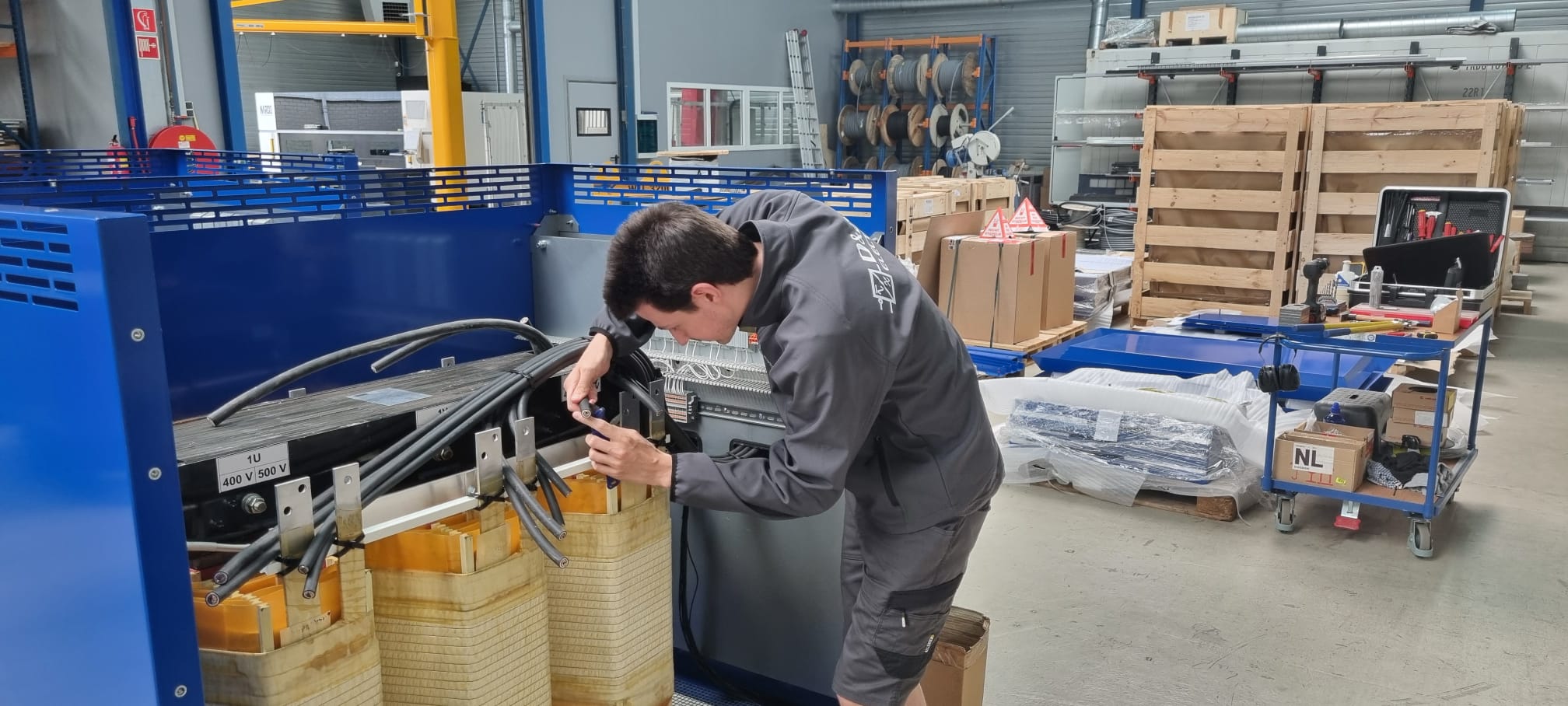 Service engineer van D&A Electric sluit de kabels van een transformator aan